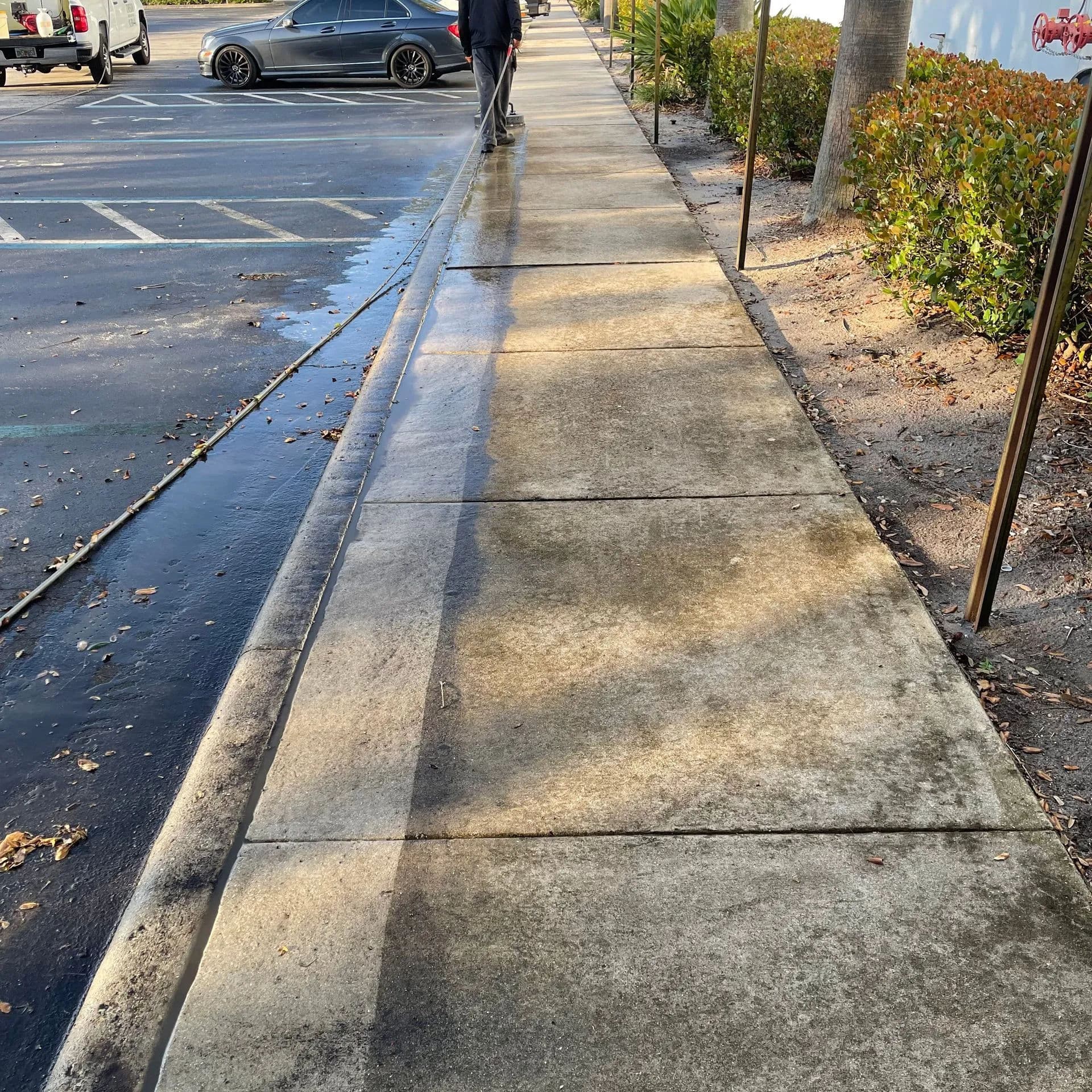 Sidewalk with sunlight casting shadows, a person walking, and paving details.